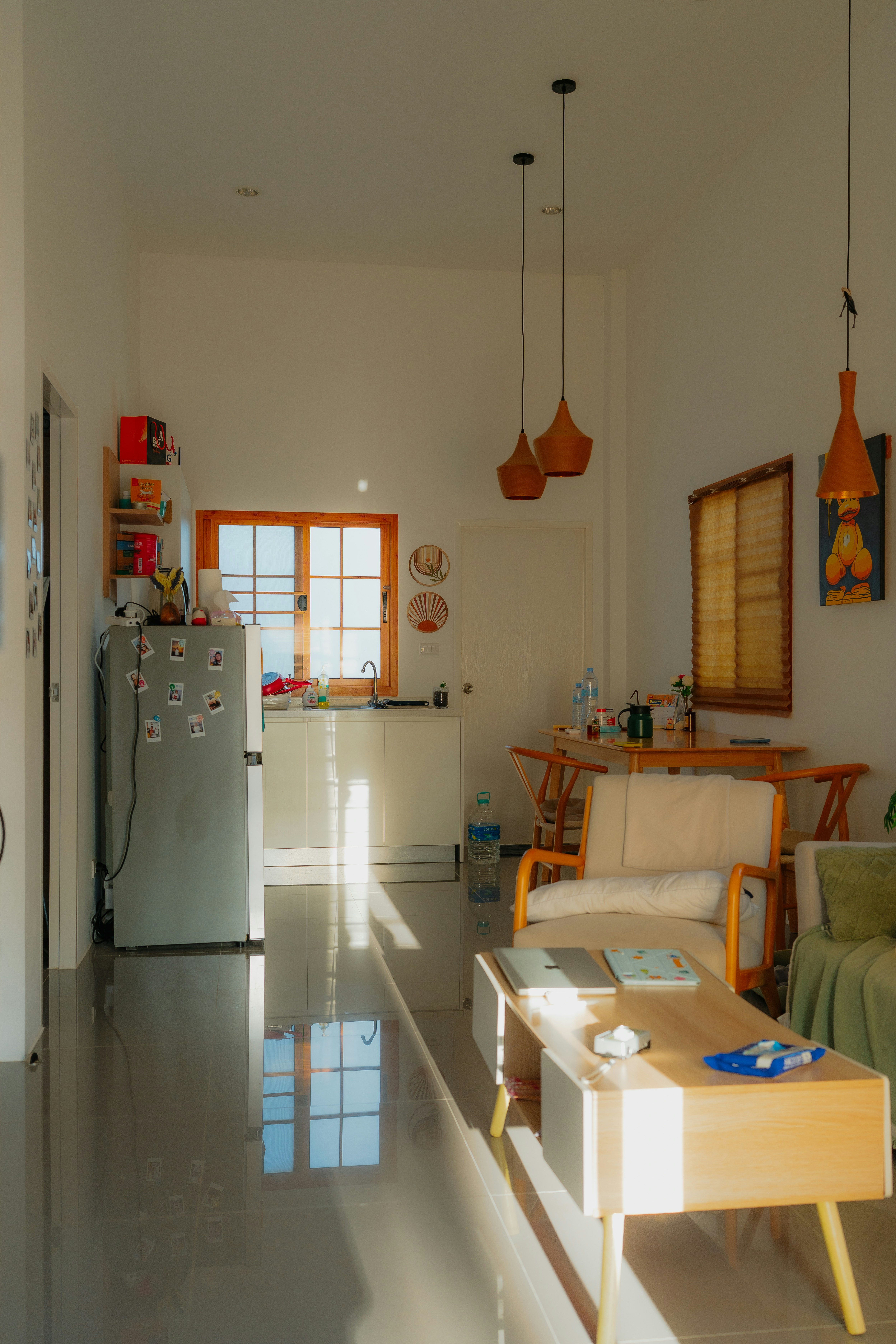 Thai condo interior — open-plan living space with high ceilings, tiled floors and pendant lighting
